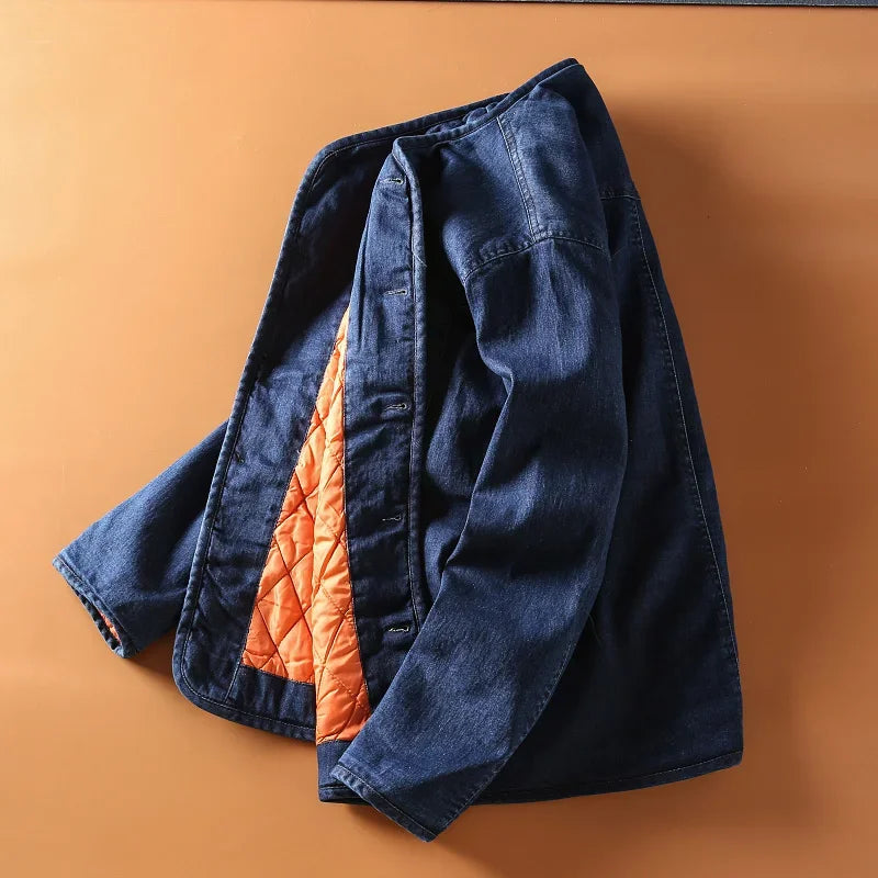 
                  
                    Blue denim jacket with orange quilted lining on a brown background
                  
                